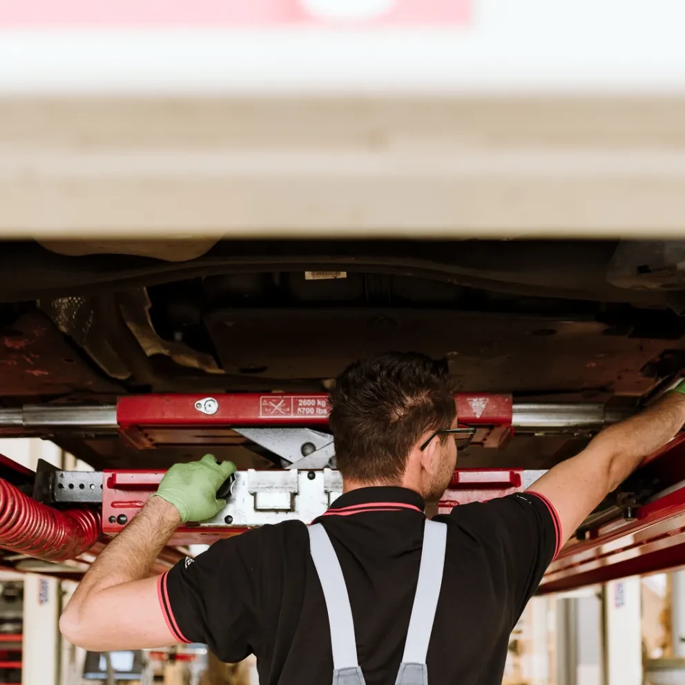 Monteur inspecteert onderzijde auto